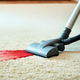 Vacuum cleaner nozzle hovering over a dirty carpet