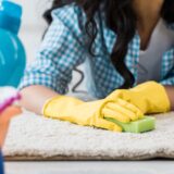 Woman cleaning carpet with a sponge