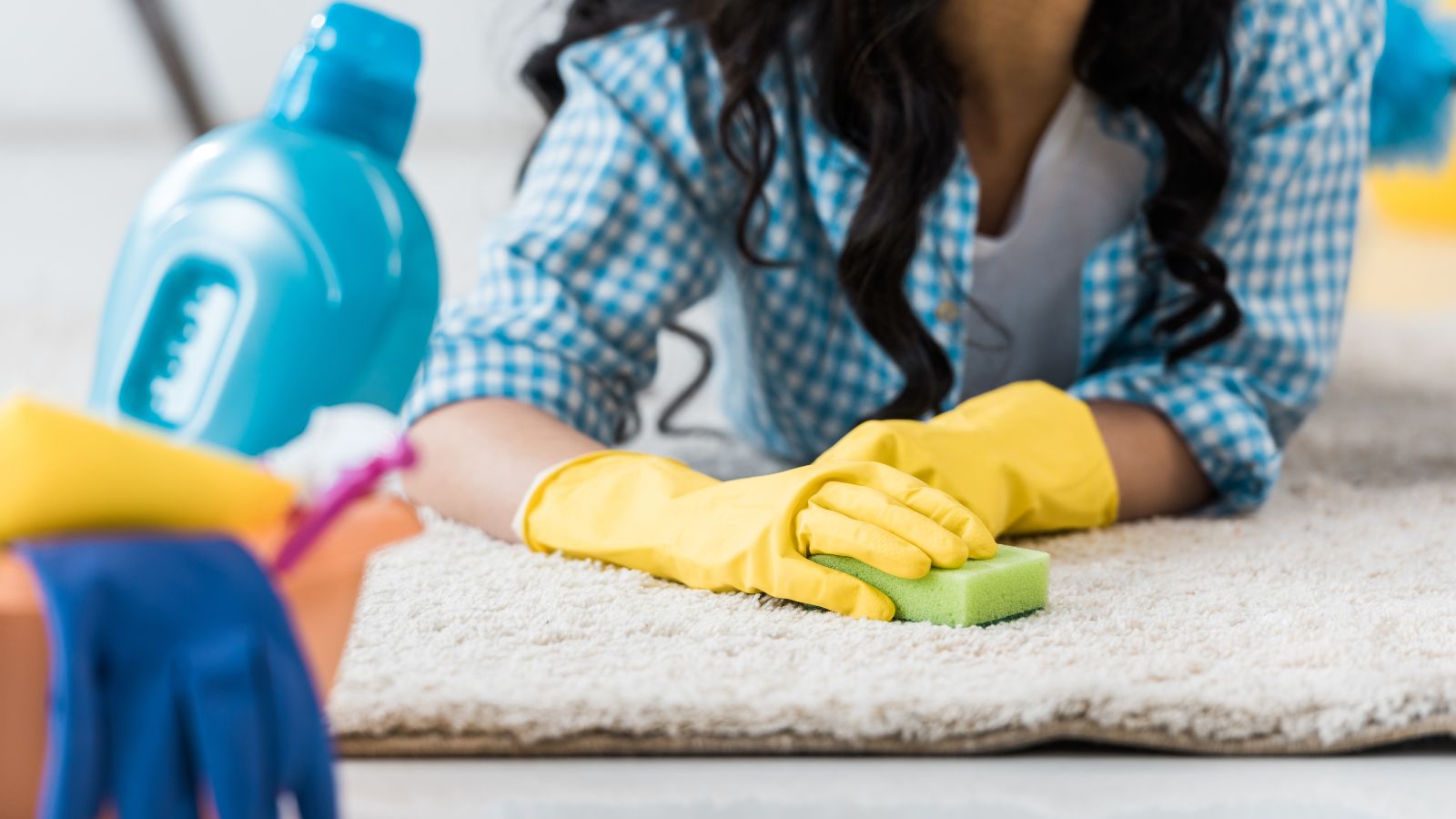 Woman cleaning carpet with a sponge