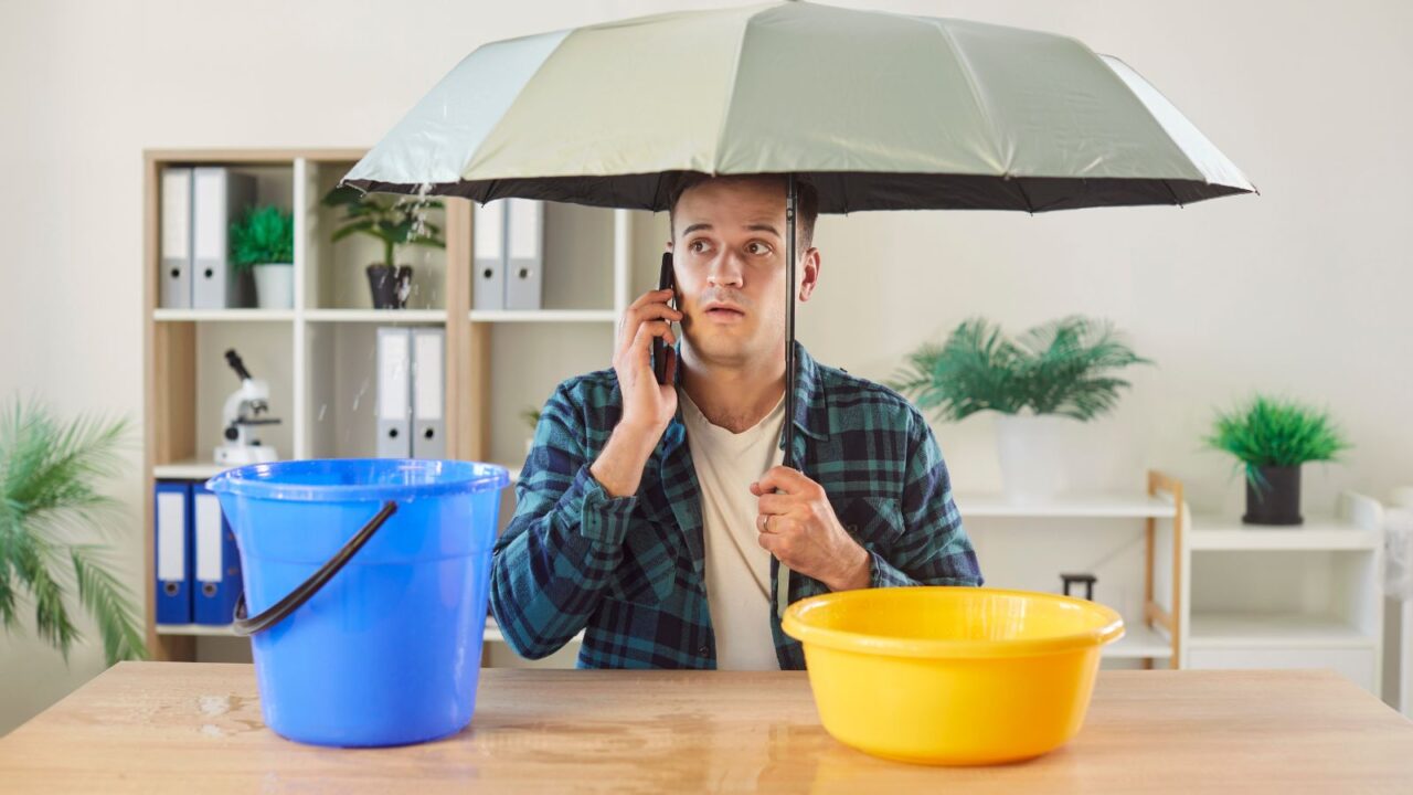 Man holding umbrella from water damage