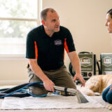 Steam Commander technician explains hot water extraction vs steam cleaning to a Cypress, TX pet owner